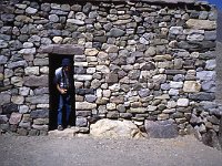 Tourist looking into a building at the Pucara de Tilcara