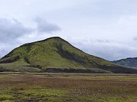 Another green hill, behind reddish grass
