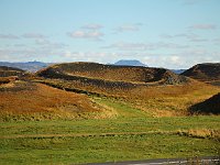 A false crater, or pseudocrater, or rootless vent. There are many of these on the south shore of Mývatn. They result not from a volcanic vent beneath them, but from an explosion when a laterally-flowing lava flow encounters a moist area and explodes.