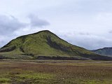 Another green hill, behind reddish grass