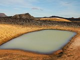 An opaque, milky-looking thermal lake and a view over the northeast lava field
