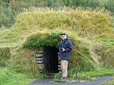 Senior tourist outside thatched storage room