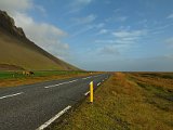 Sunny road going on eastwards towards Vík